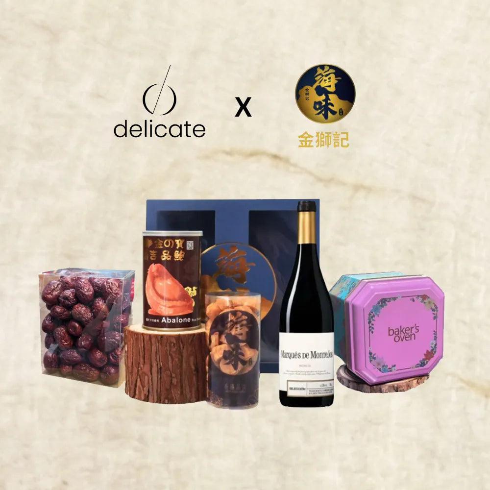 Collection of gourmet products including a bottle of wine and packaged items on a textured beige background with 'delicate' branding.